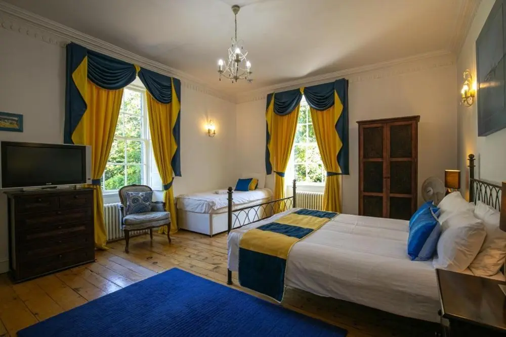 a bedroom with a large bed and a television at Cortes House in Fraserburgh