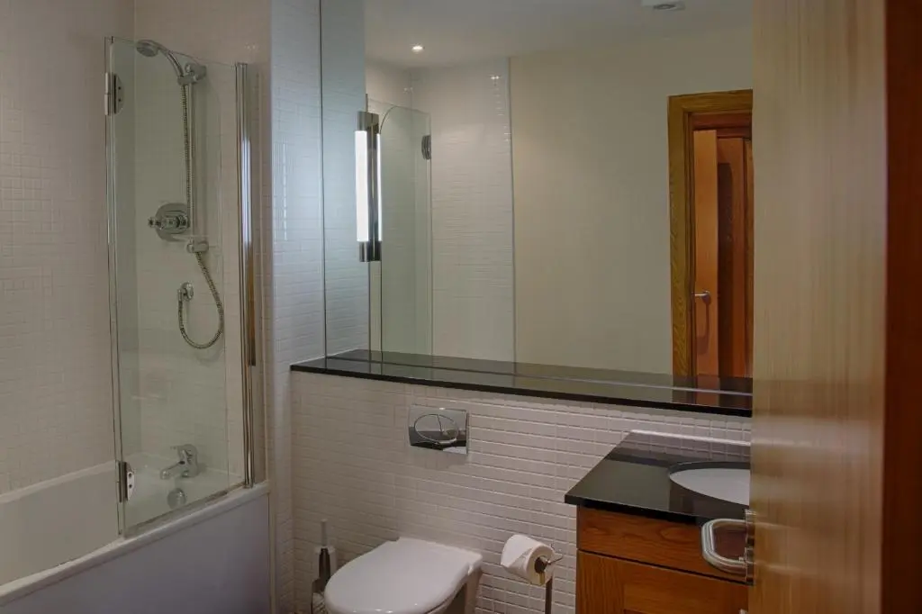 a bathroom with a toilet and a sink and a shower at Links Apartment in Brora