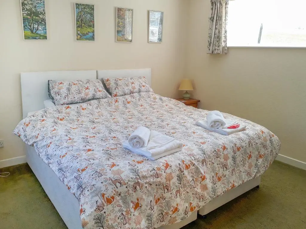 a bedroom with a bed with towels on it at Ivy Cottage in Mountblairy