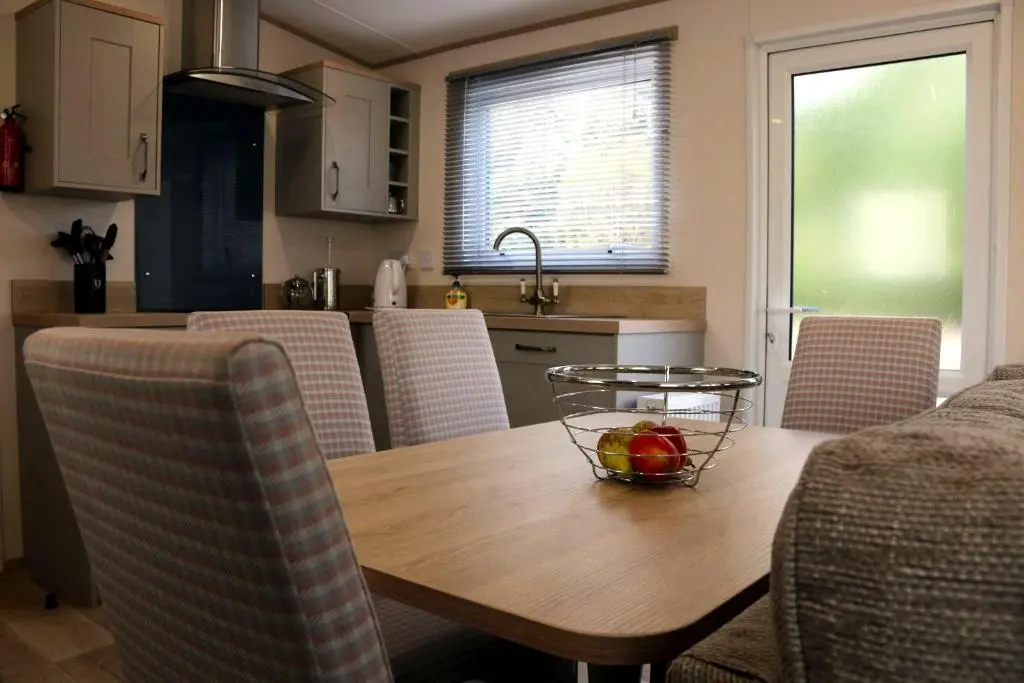 a kitchen with a wooden table with a bowl of fruit on it at Feorag Lodge in Aviemore