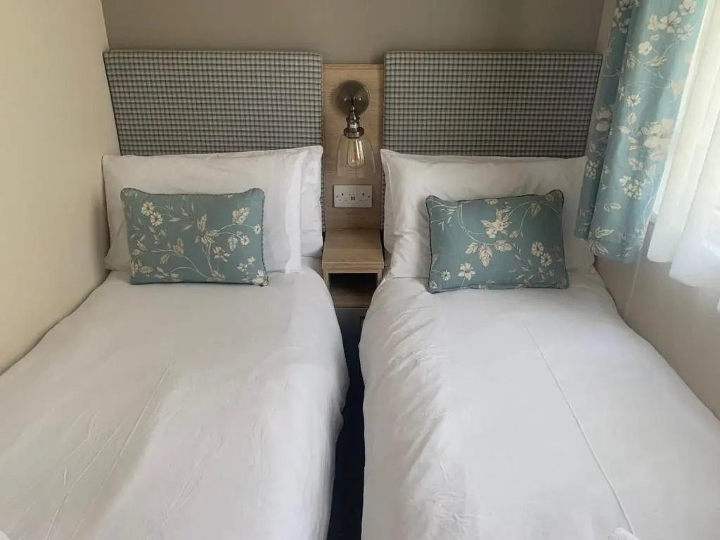 two beds sitting next to each other in a bedroom at Feorag Lodge in Aviemore