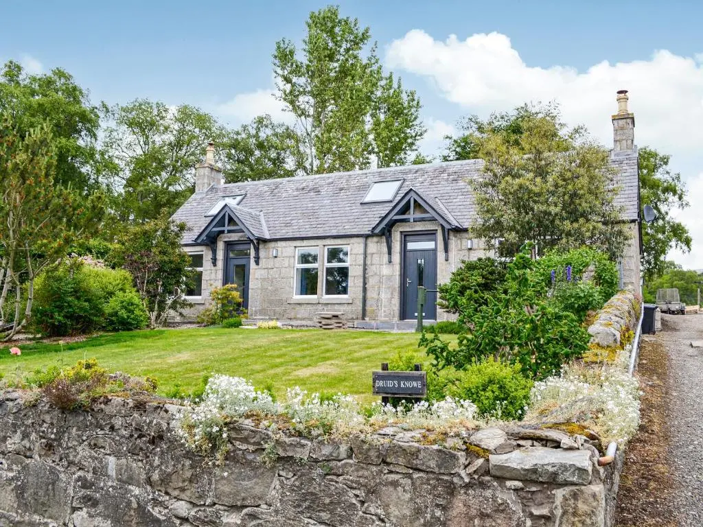 a stone house with a stone wall at Druids Knowe in Tarfside