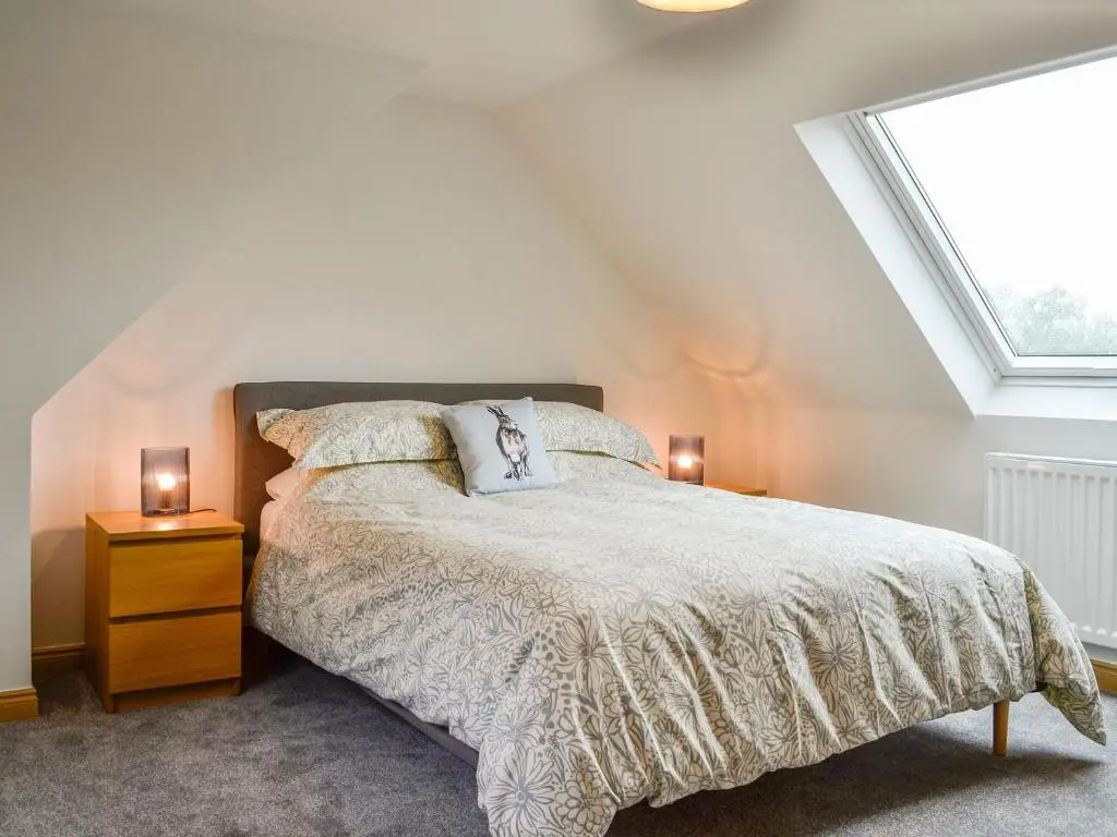 a bedroom with a bed and two lamps on tables at Druids Knowe in Tarfside