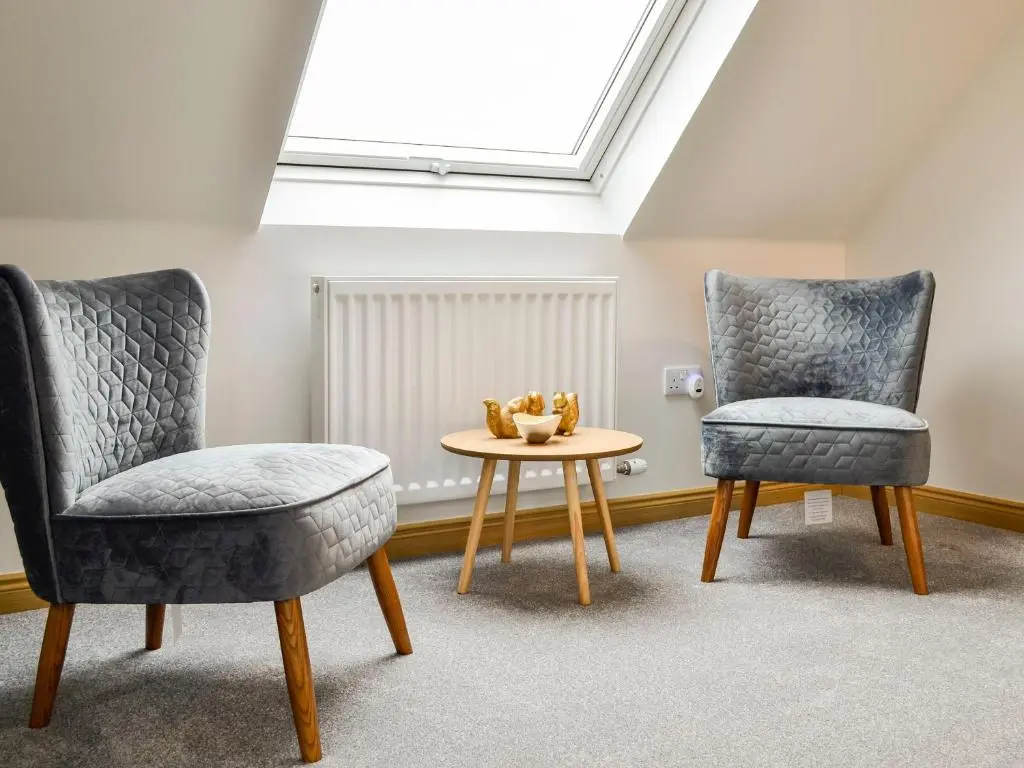 two chairs and a table in a room at Druids Knowe in Tarfside