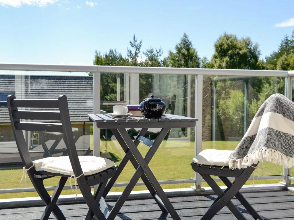 a picnic table and two chairs on a deck at Queen's View Lodge in Inchmarlo