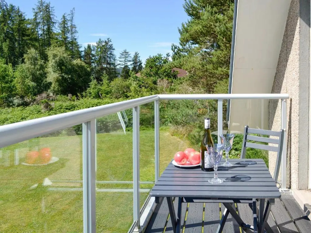 a blue table with a glass of wine on a balcony at Queen's View Lodge in Inchmarlo
