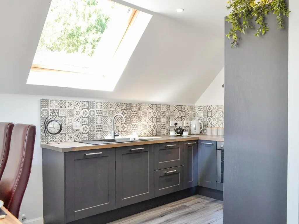 a kitchen with gray cabinets and a skylight at Queen's View Lodge in Inchmarlo