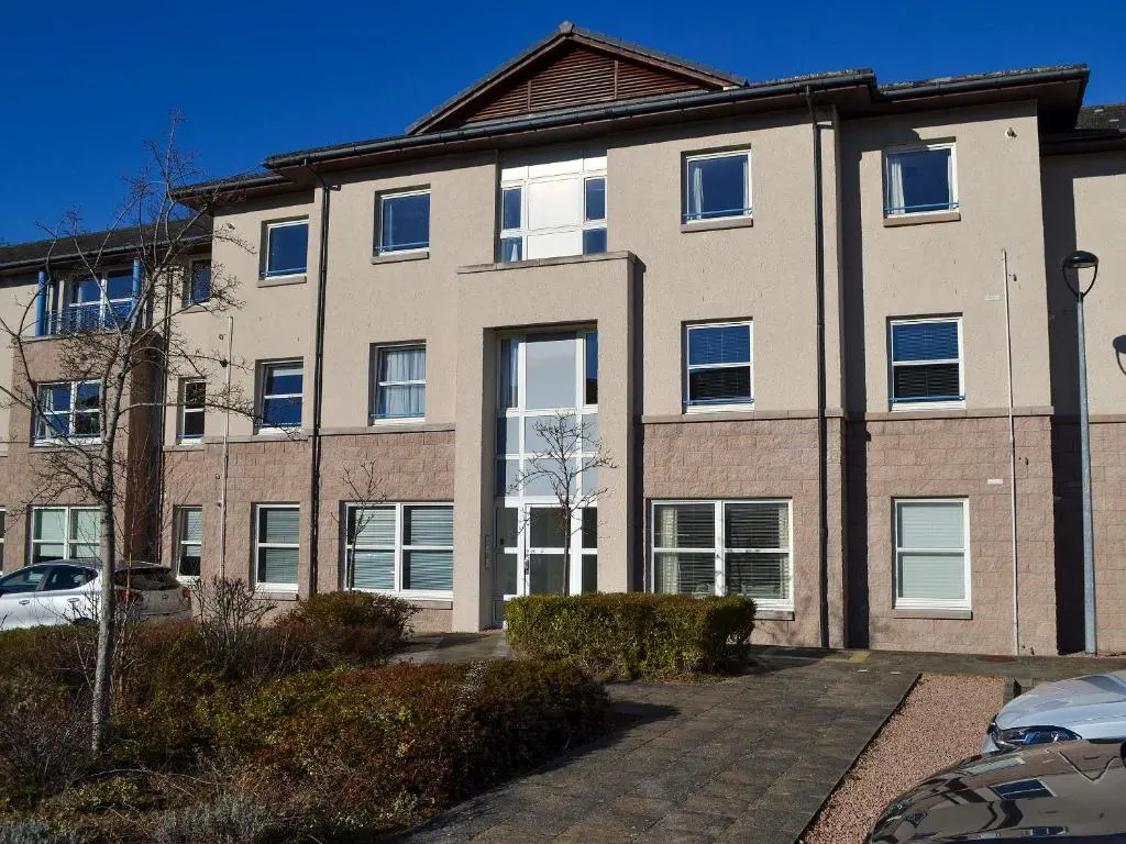 a large brick building with white windows at Ness-Side Apartment in Inverness