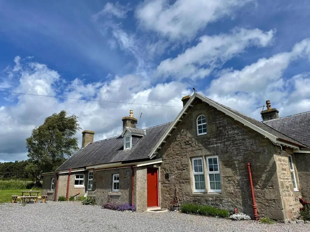 an old stone house with a red door at Birch Cottage - Uk38992 in Dalcross