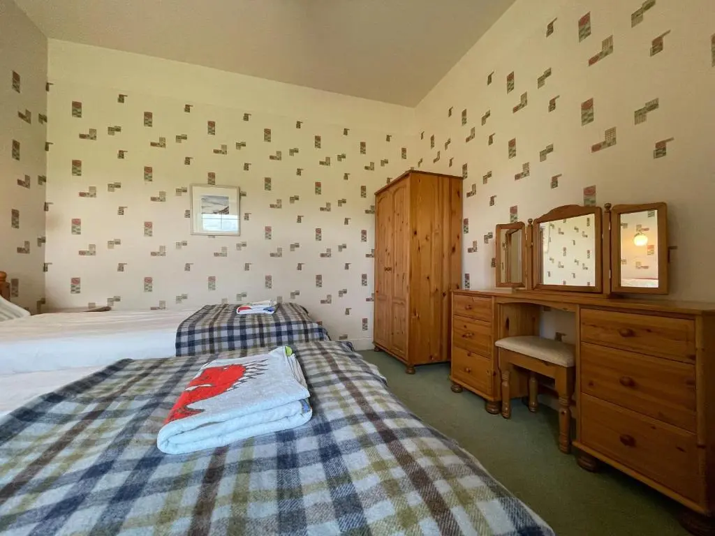 a bedroom with a bed and a dresser and a desk at Birch Cottage - Uk38992 in Dalcross