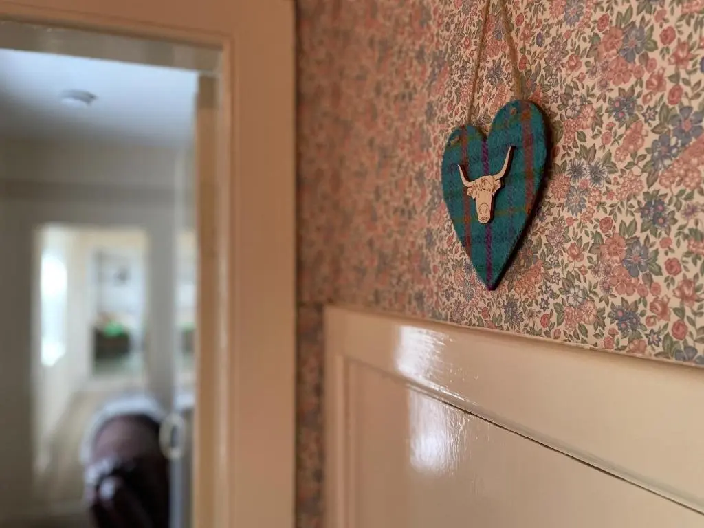 a heart hanging on a wall next to a door at Birch Cottage - Uk38992 in Dalcross