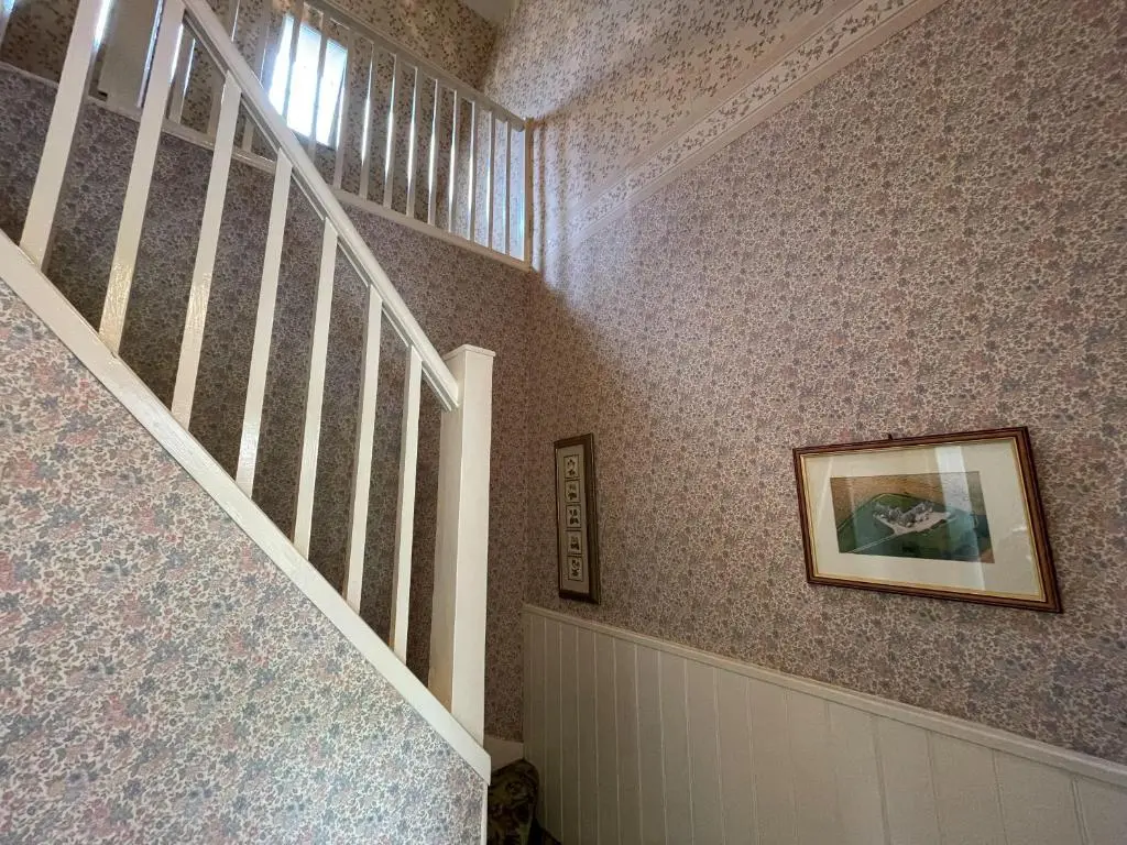 a staircase with a picture on the wall and a stair case at Birch Cottage - Uk38992 in Dalcross