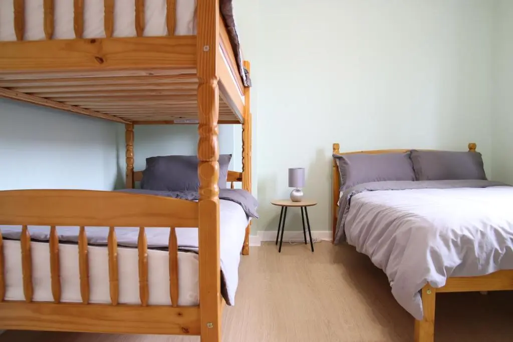 a bedroom with two bunk beds and a table at Aria Lodging Inverness in Inverness