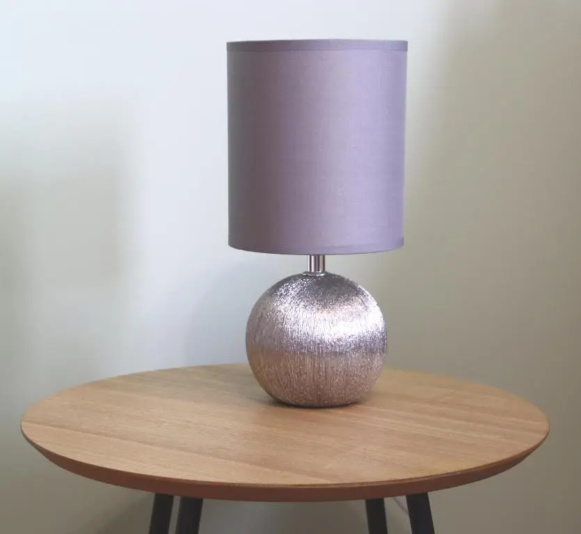 a lamp sitting on top of a wooden table at Aria Lodging Inverness in Inverness