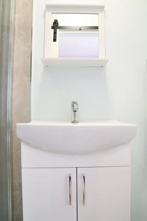 a bathroom with a white sink and a mirror at Aria Lodging Inverness in Inverness
