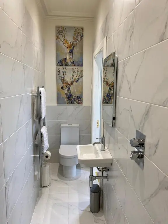a white bathroom with a sink and a toilet at Beinn Mhor Lodge, 63 Culduthel Road in Inverness