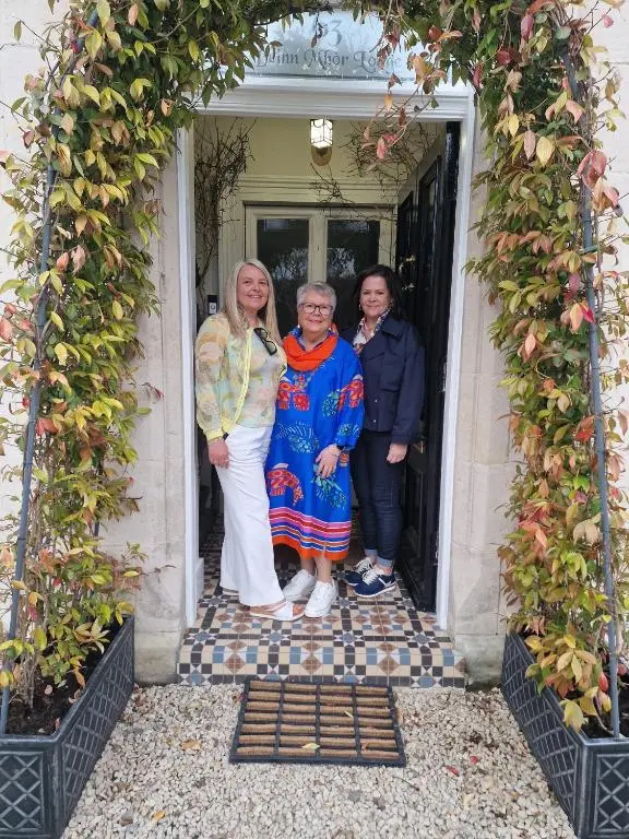 three people standing in the doorway of a house at Beinn Mhor Lodge, 63 Culduthel Road in Inverness