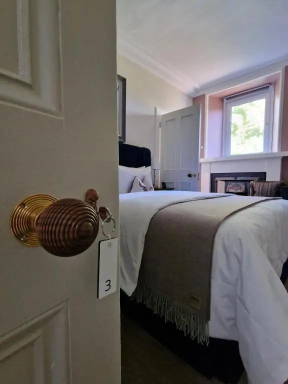 a bedroom with a bed and a door with a clock on it at Beinn Mhor Lodge, 63 Culduthel Road in Inverness