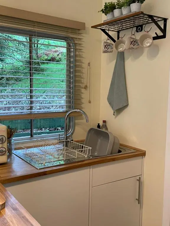 a kitchen counter with a sink and a window at The Cabin, Stronua. A beautiful 1 bedroom cabin. in Fort Augustus