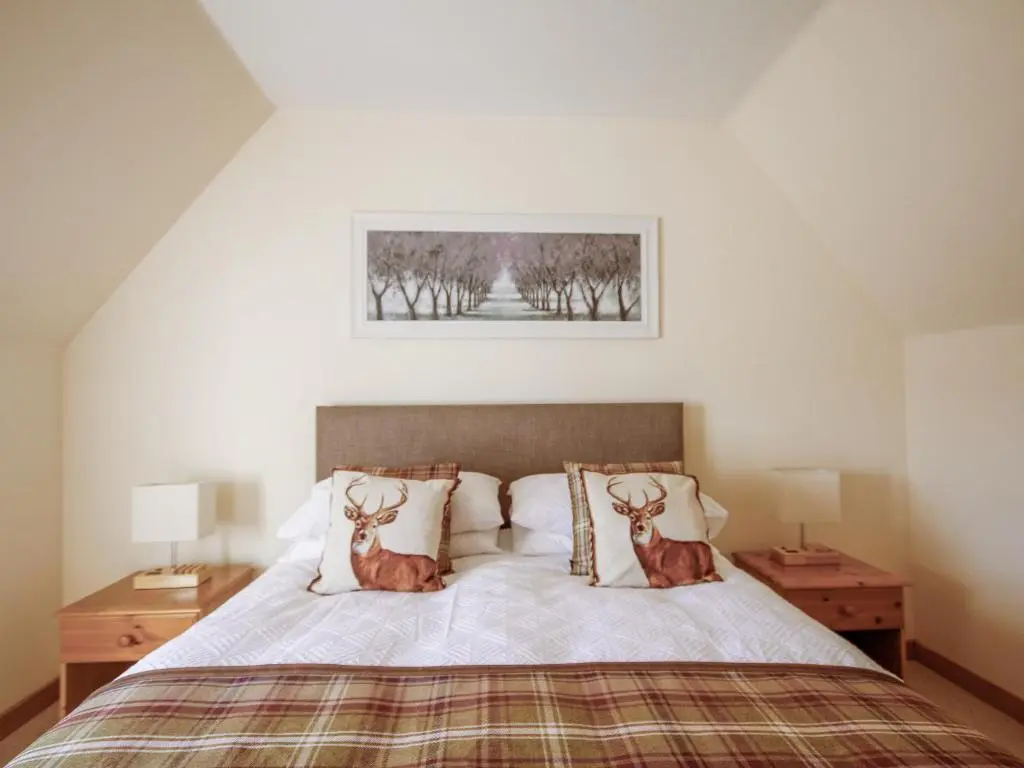 a bedroom with a bed with pillows on it at Hill Cottage in Ardmair