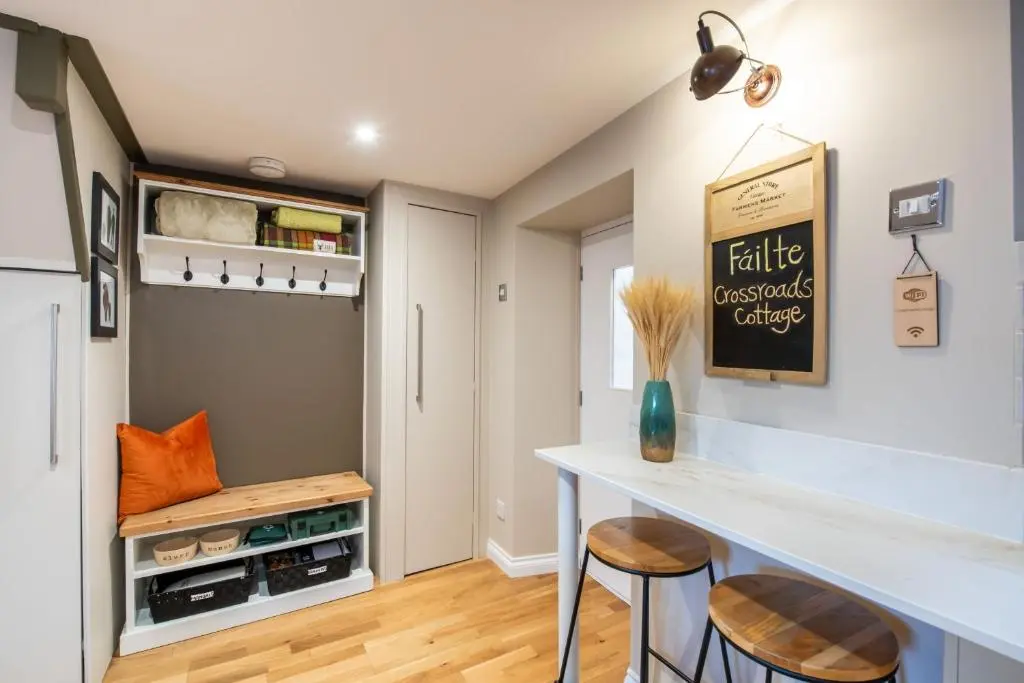 a kitchen with a counter and two stools at Crossroads Cottage in Drumnadrochit