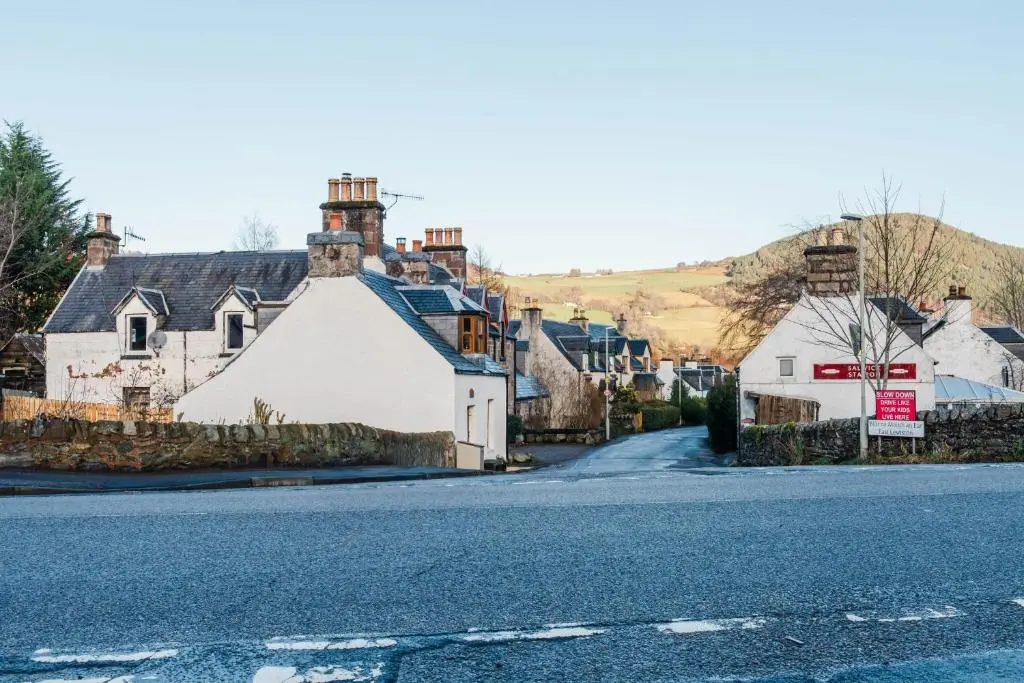 an empty street in a small village with houses at Crossroads Cottage in Drumnadrochit