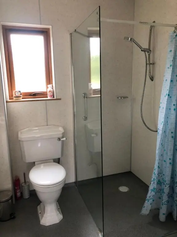 a bathroom with a toilet and a glass shower at River Ness View in Inverness