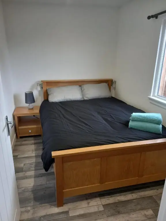 a bedroom with a bed with a wooden bed frame at Full Pint in Tain