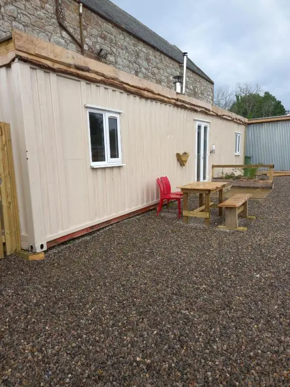 a picnic table and a bench next to a building at Half Pint in Tain