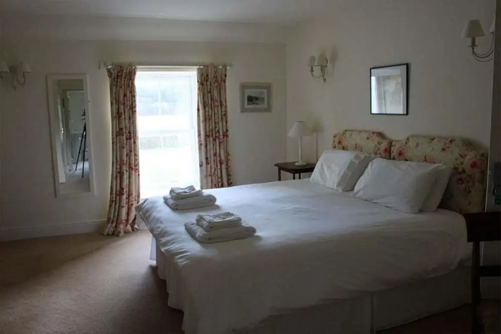a bedroom with a large bed with towels on it at Garbity Farmhouse - beautiful 6-bedroom Farmhouse with open fires in Fochabers