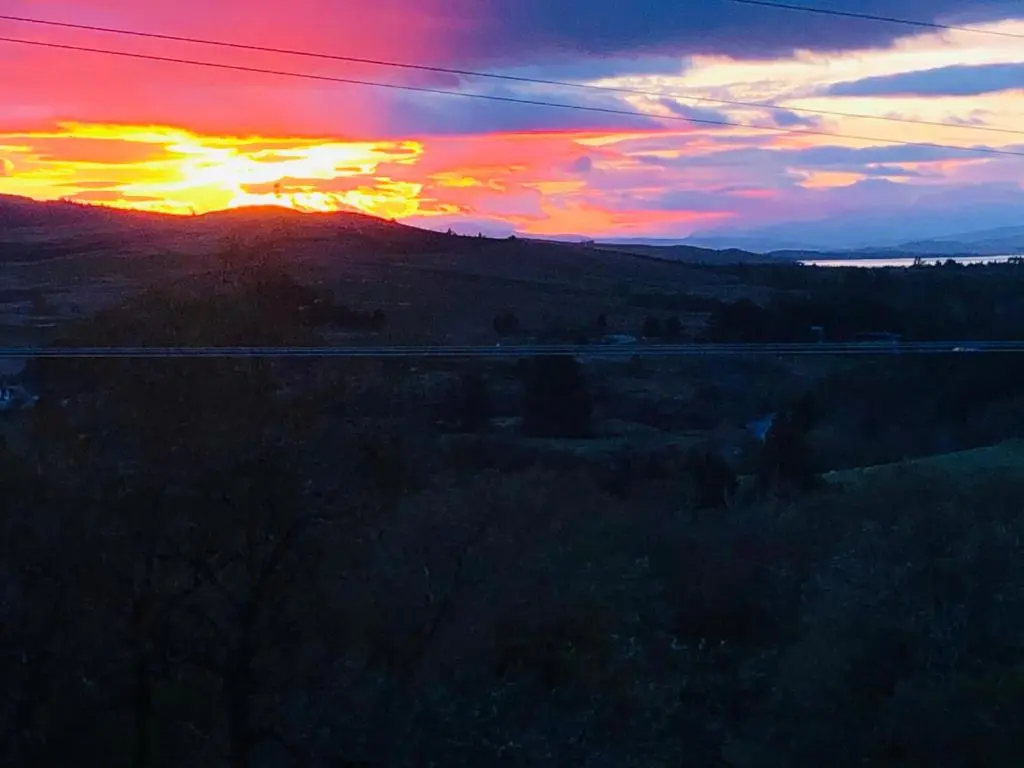 a sunset over a field with a train at Ben Klibreck, Ben Hope, Ben Hee in Torroboll