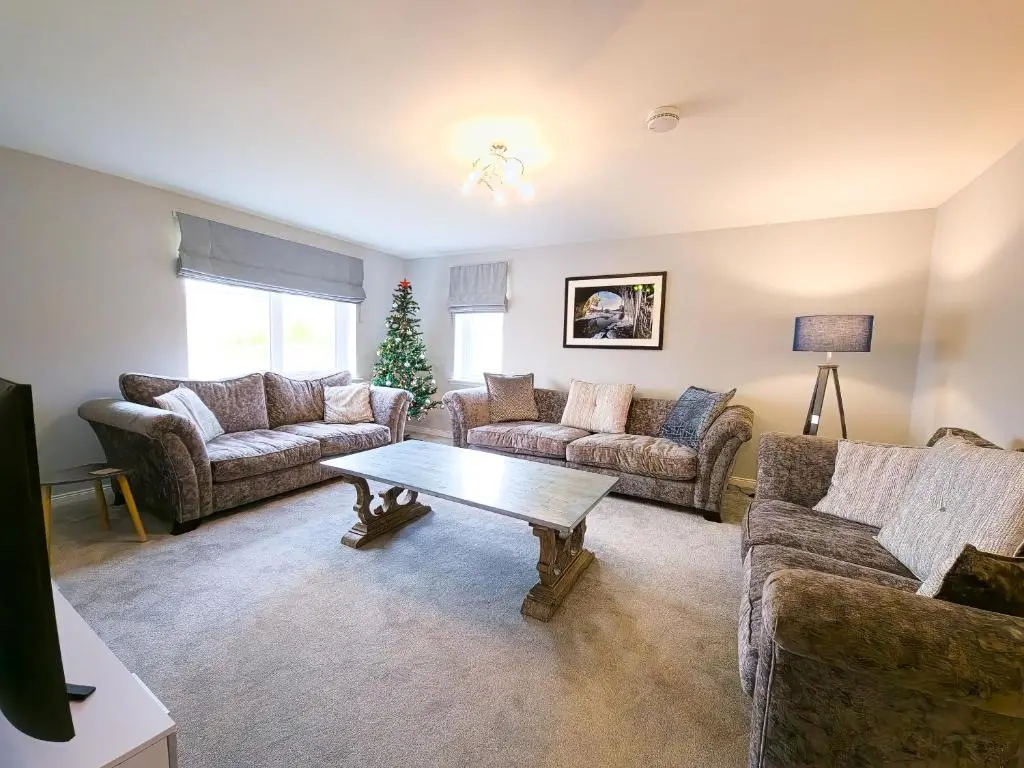 a living room with couches and a coffee table at Braeside - Family home in Nethy Bridge in Nethy Bridge