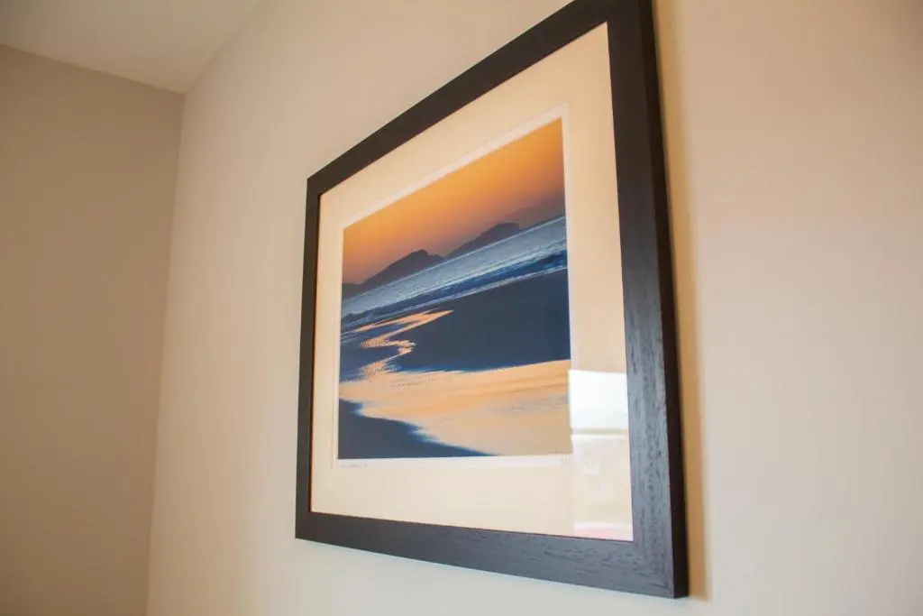 a framed picture of the ocean on a wall at Braeside - Family home in Nethy Bridge in Nethy Bridge