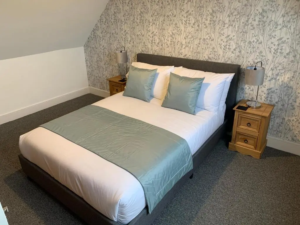 a bedroom with a large bed with blue and white pillows at Caithness Stone house in Wick