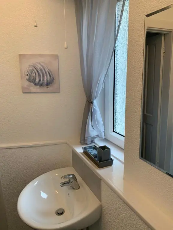 a bathroom with a sink and a mirror at Caithness Stone house in Wick