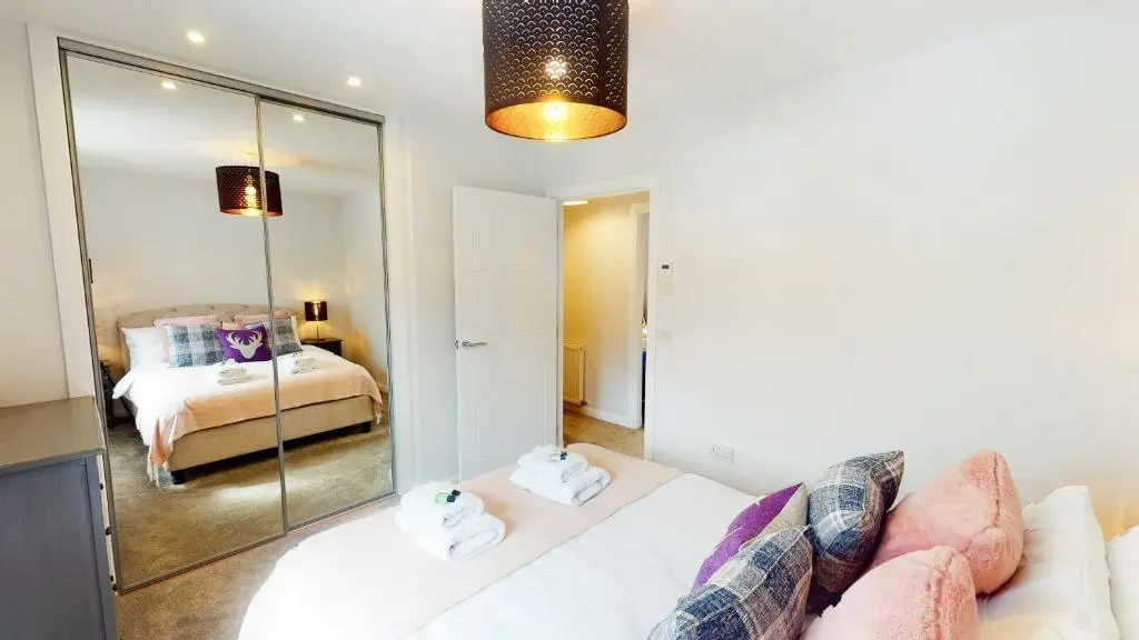 a living room with a white couch and a bedroom at 10 Bynack House in Aviemore