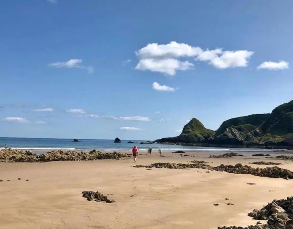a person walking on a beach near the ocean at Garbity Cottage in Fochabers
