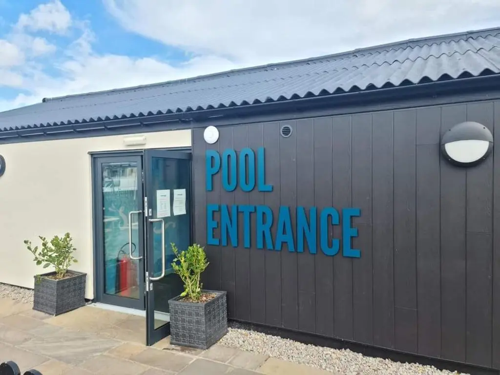 a building with a sign that reads pool entrance at Aurora Way 81 in Lossiemouth