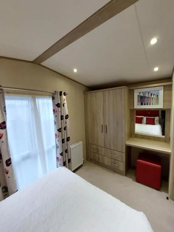 a bedroom with a white bed and a window at Aurora Way 81 in Lossiemouth