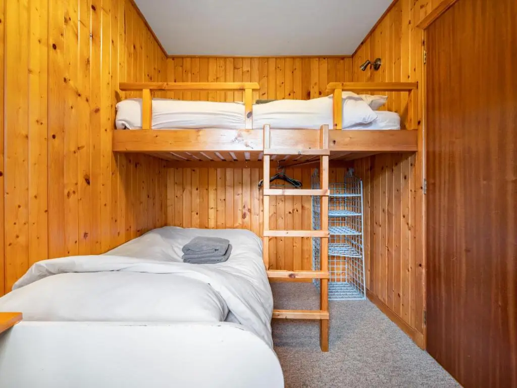 two bunk beds in a room with wooden walls at Divach Lodge at Lochletter Lodges in Drumnadrochit