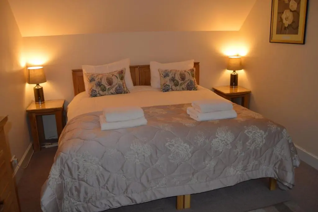 a bedroom with a large bed with towels on it at Ness View Apartment in Inverness