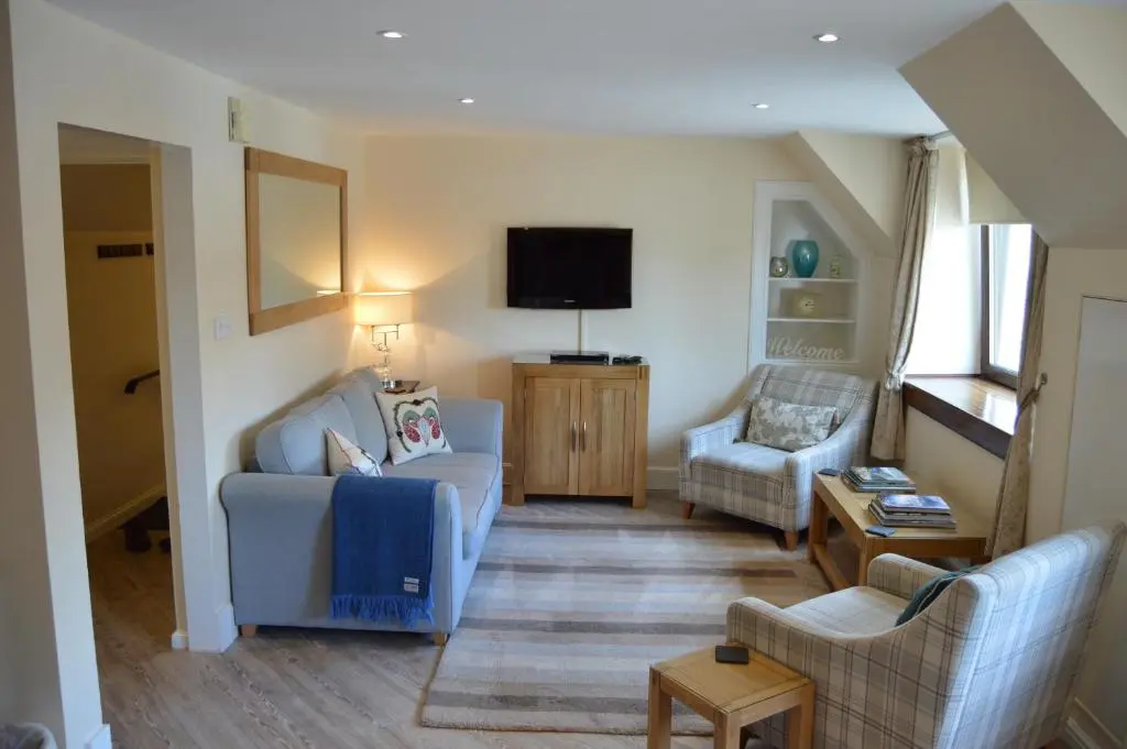 a living room with a couch and a tv at Ness View Apartment in Inverness