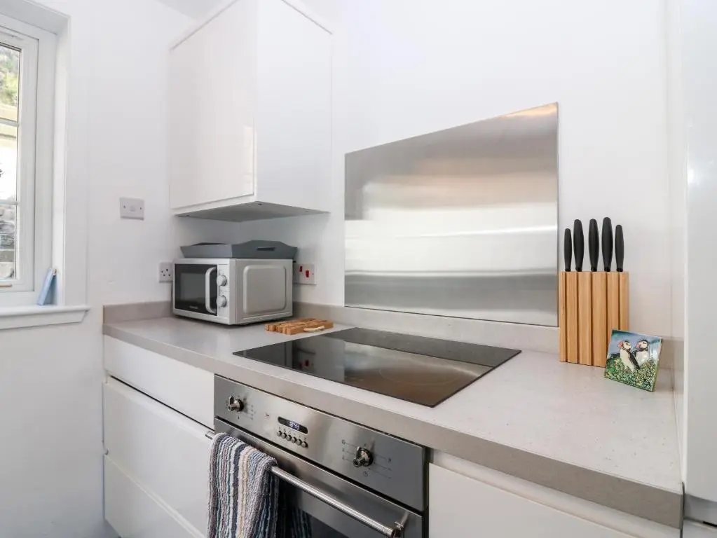 a kitchen with a sink and a microwave at Dolphin Cottage in Banff