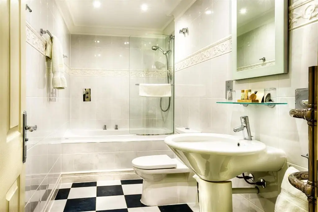 a bathroom with a sink and a toilet and a tub at Mansion House Hotel in Elgin