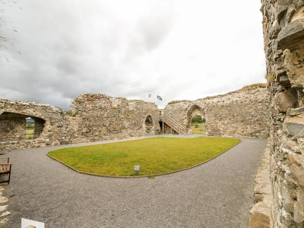 an old stone building with a grassy yard in front of it at Ulla Dhu in Nethy Bridge