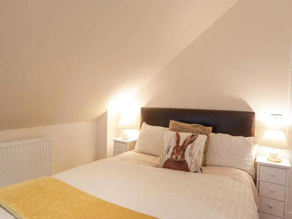 a bedroom with a large bed with two lamps at Ballinreich in Inverness