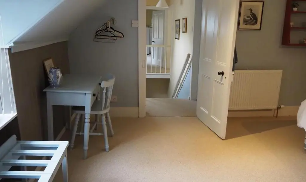 a room with a desk and a table and a staircase at The Fiddichside Inn in Aberlour