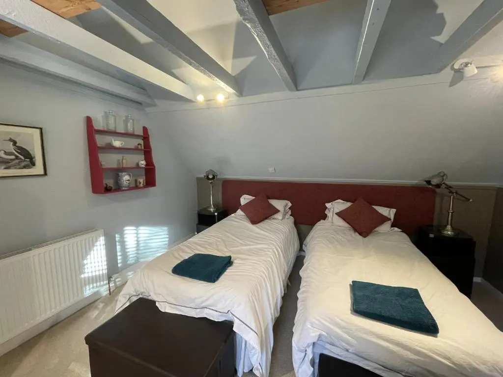 two beds in a room with two pillows on them at The Fiddichside Inn in Aberlour
