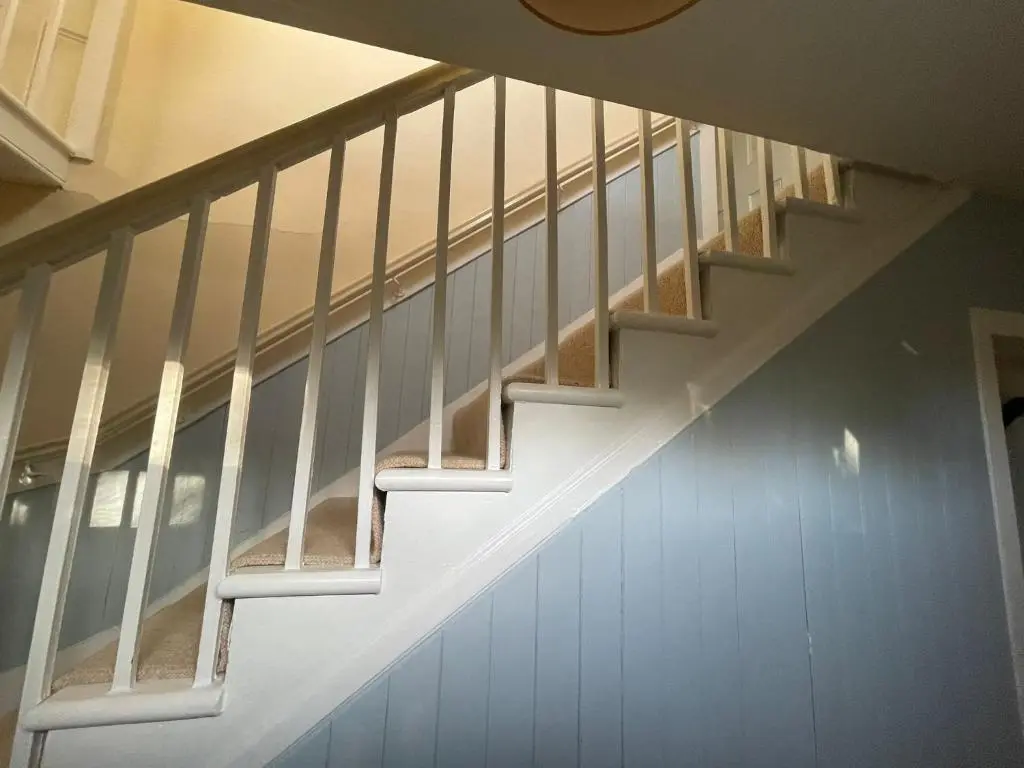 a staircase with white railings in a house at The Fiddichside Inn in Aberlour