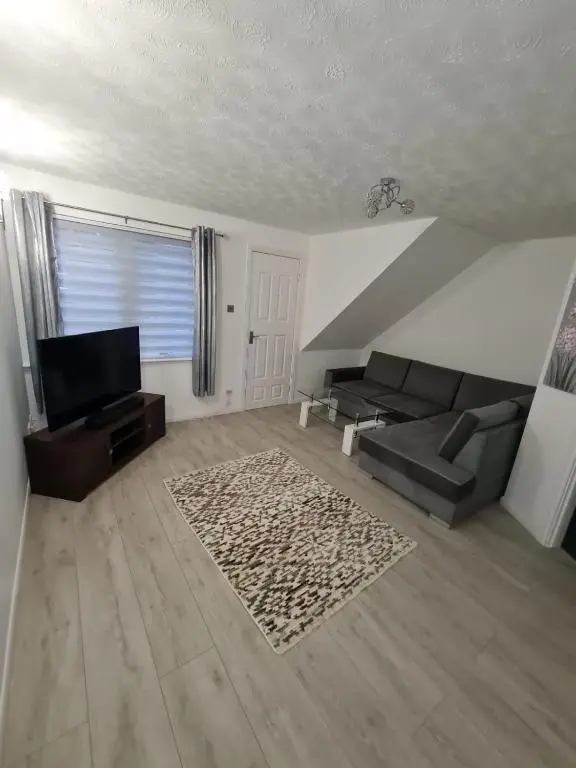a living room with a couch and a television at Lovely 2 bedroom flat in nice Inversness area. in Inverness